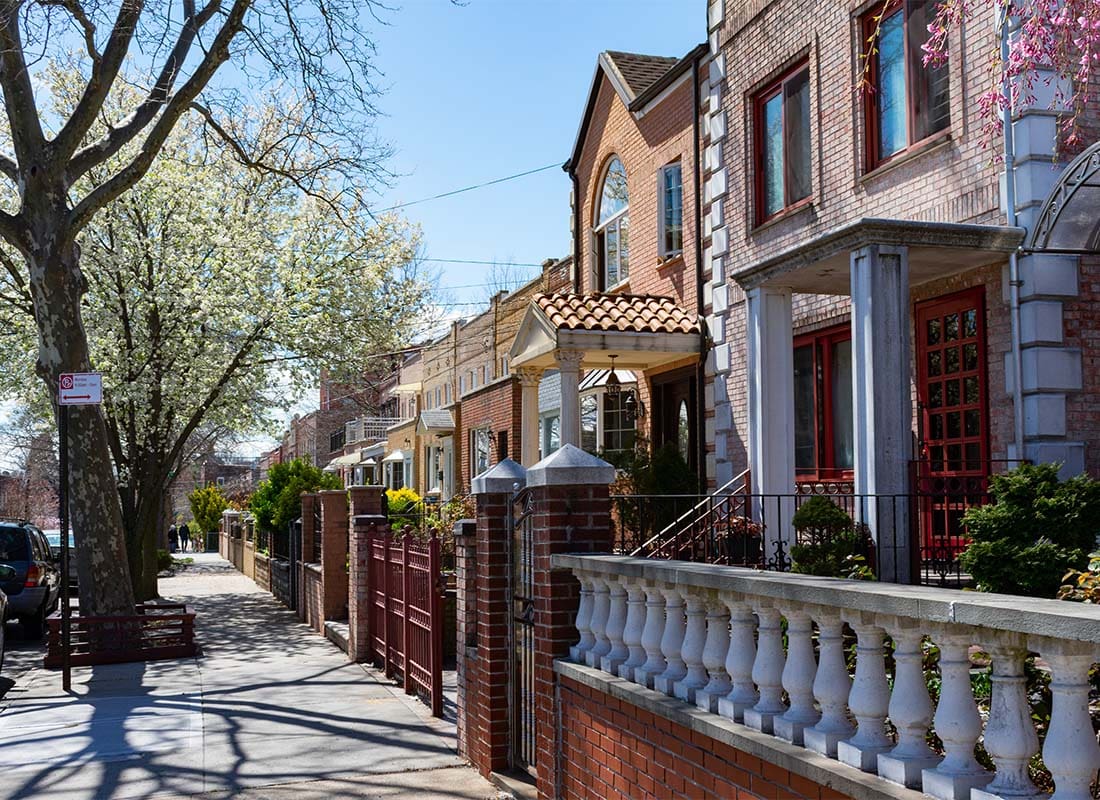 Ozone Park, NY - Row of Two Story Homes in a Quiet Neighborhood in Ozone Park New York with Blooming Trees on the Sidewalk